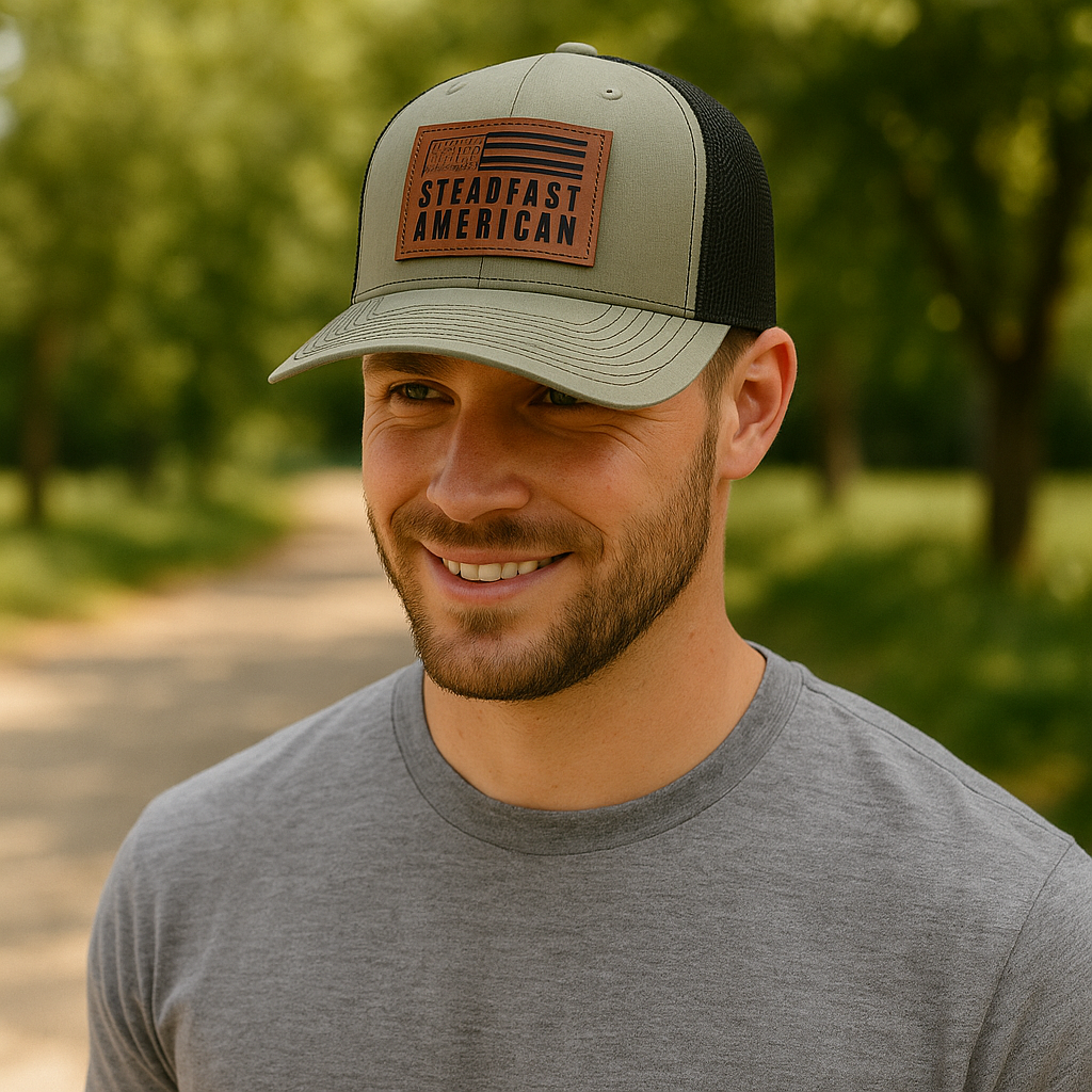 Man wearing a cap with 'Steadfast American' leather patch logo outdoors